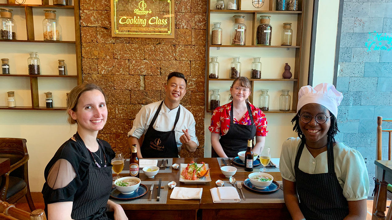New friends laughing during a cooking class in Hanoi Old Quarter
